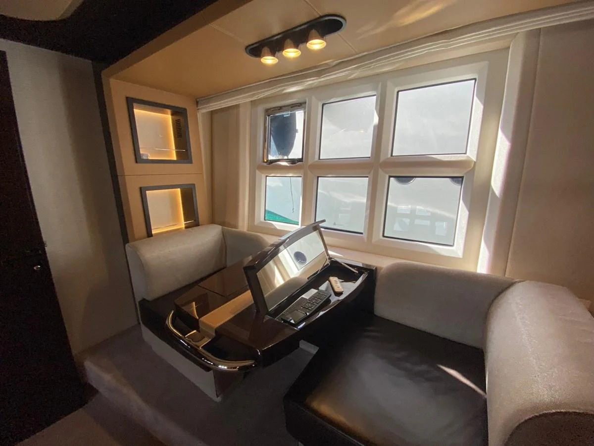 a living room with a laptop on a coffee table aboard 10009846 Yacht for Sale