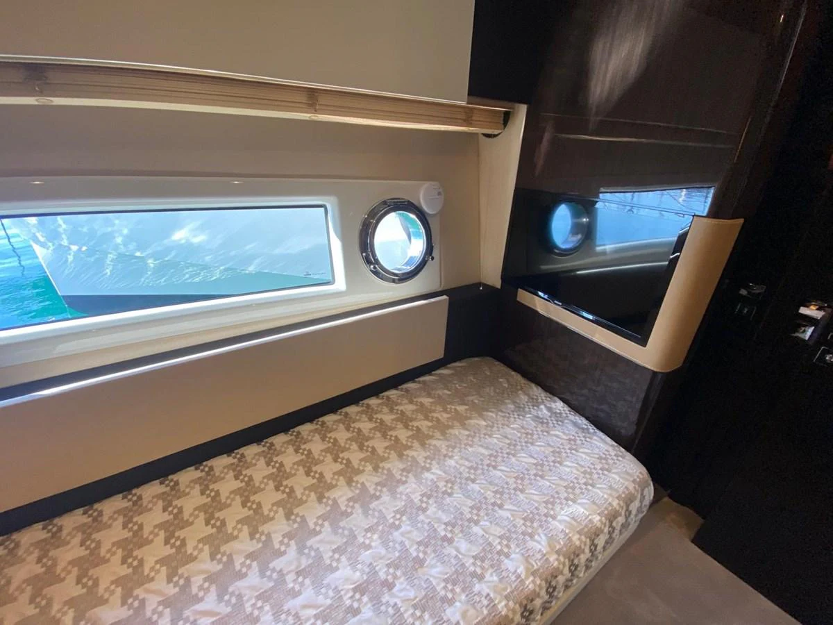 a bed with a round window aboard 10009846 Yacht for Sale