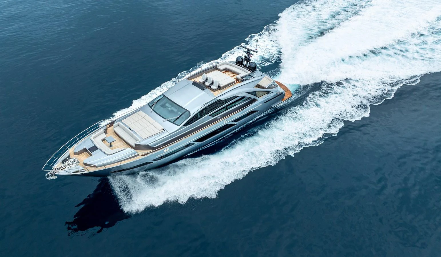 A sleek and modern yacht cruises swiftly through the open water, leaving a trail of white wake behind. aboard MAVIS Yacht for Sale