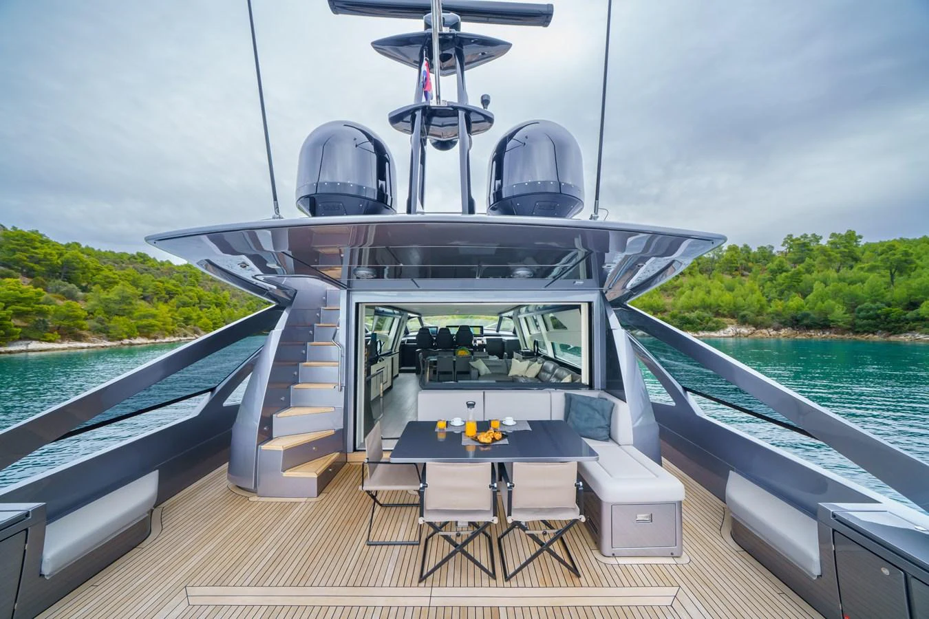 The aft deck features a stylish dining area with a view of the serene waters and lush greenery. aboard MAVIS Yacht for Sale
