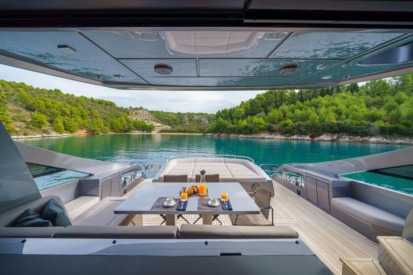 The aft deck offers a luxurious dining area with stunning views of the surrounding waters and lush greenery. aboard MAVIS Yacht for Sale
