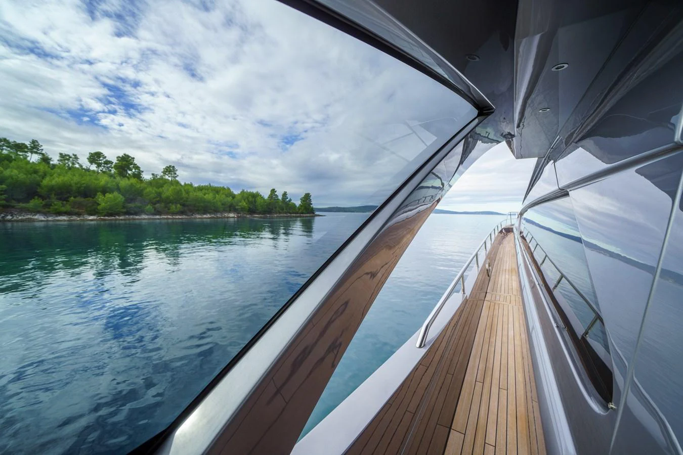 A sleek yacht glides smoothly along a serene waterway, reflecting the tranquil surroundings. aboard MAVIS Yacht for Sale