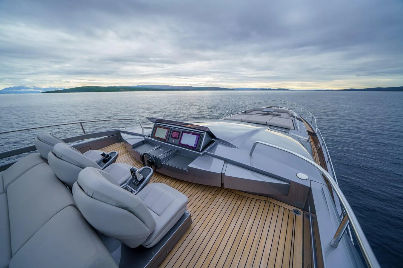 The yacht's helm offers a sleek and modern design with comfortable seating and advanced navigation systems, set against a serene ocean backdrop. aboard MAVIS Yacht for Sale