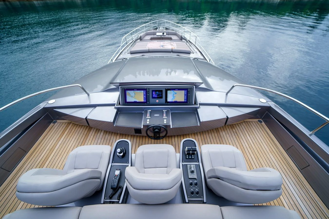 The yacht's helm station features state-of-the-art navigation equipment and luxurious seating, set against a serene waterfront backdrop. aboard MAVIS Yacht for Sale