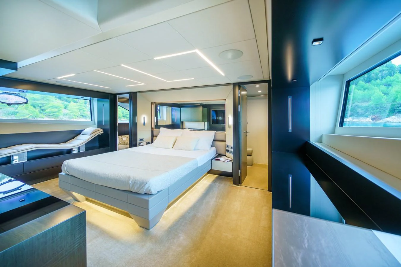 The master stateroom features a spacious bed, modern lighting, and large windows offering scenic views. aboard MAVIS Yacht for Sale
