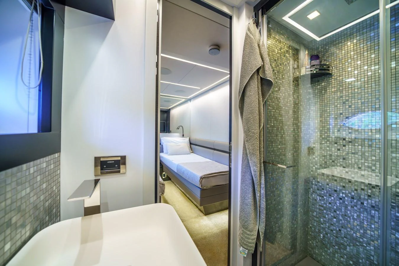 A modern yacht bathroom with a view into a cozy stateroom. aboard MAVIS Yacht for Sale