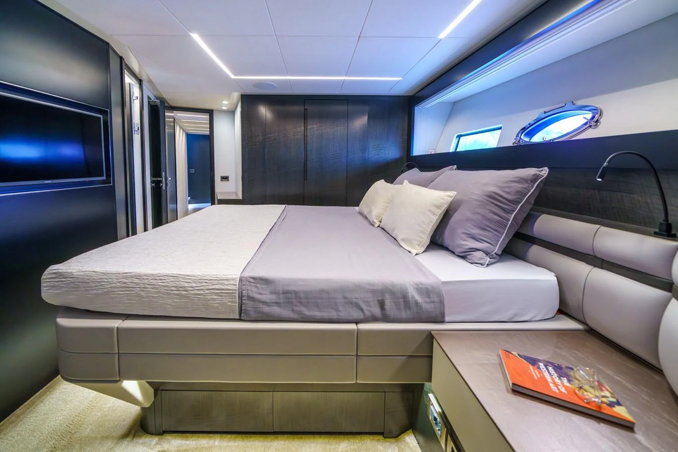 The stateroom features a luxurious bed with modern decor and ample natural light. aboard MAVIS Yacht for Sale