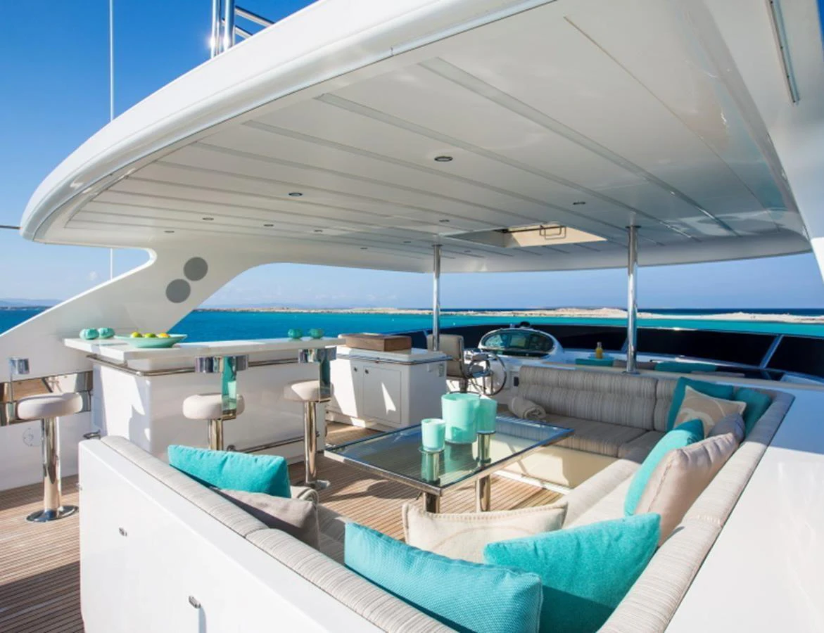 The flybridge features a spacious seating area with turquoise accents and panoramic ocean views. aboard MR & MRS SMITH Yacht for Sale