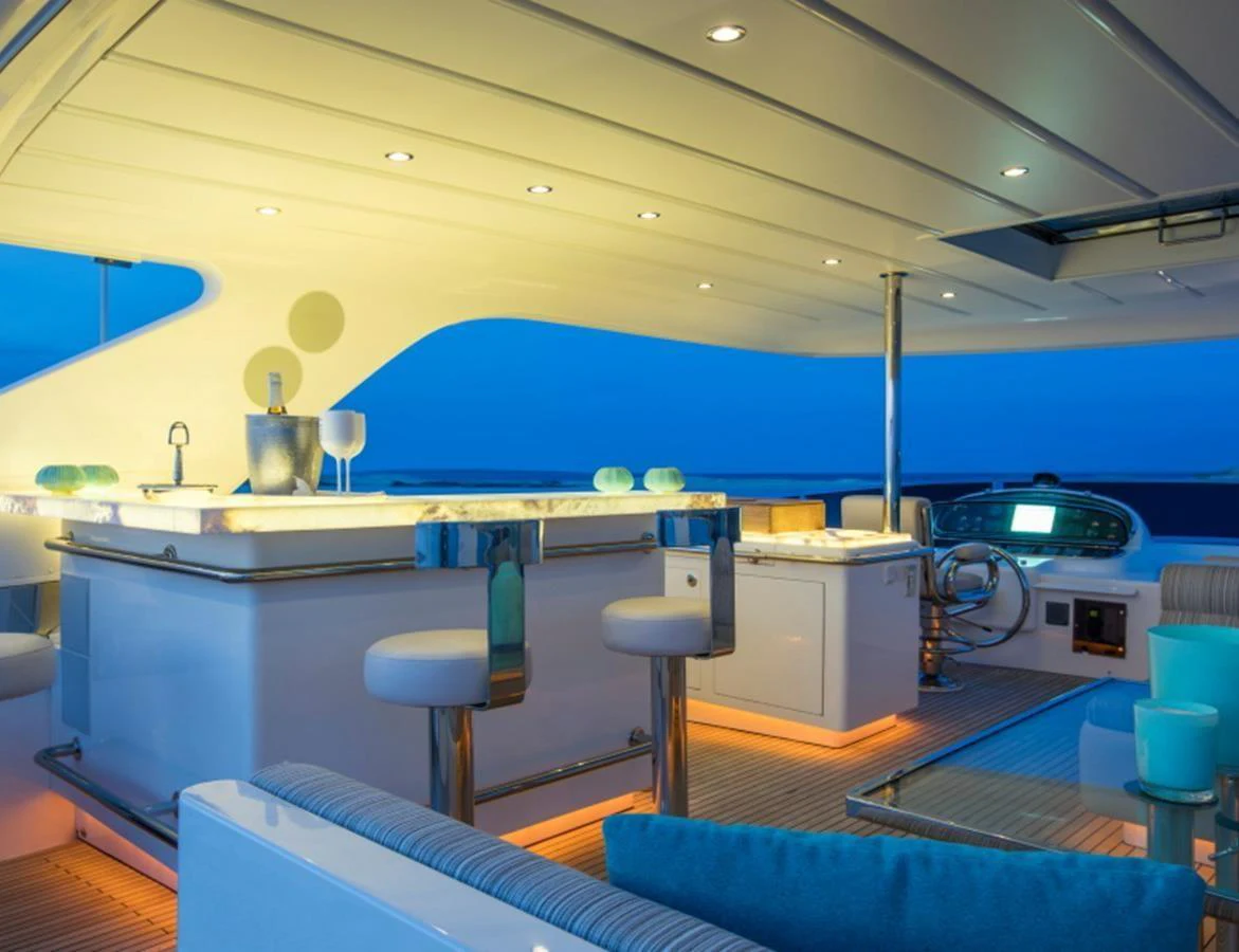 The flybridge features a stylish bar area with comfortable seating and ambient lighting. aboard MR & MRS SMITH Yacht for Sale