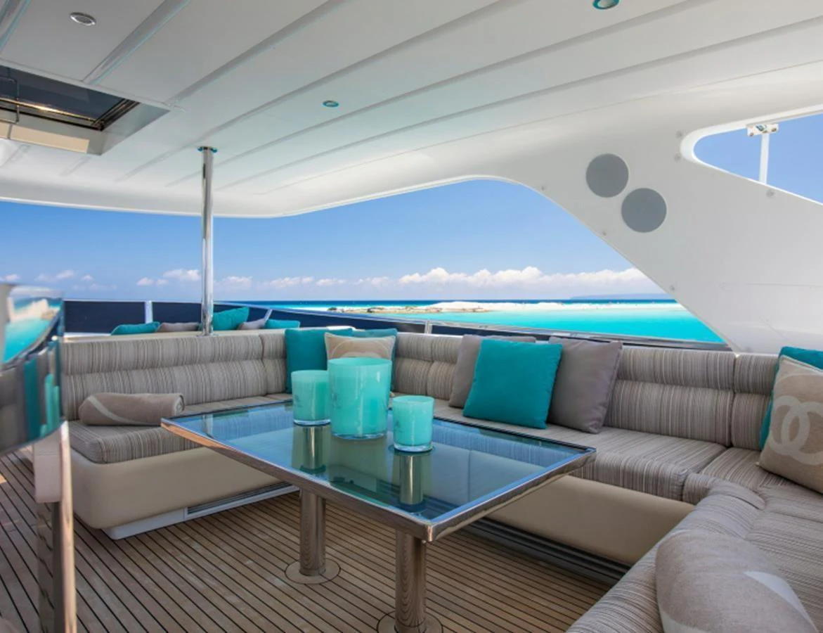 The yacht features a stylish outdoor lounge area with comfortable seating and a glass table, perfect for enjoying the ocean views. aboard MR & MRS SMITH Yacht for Sale