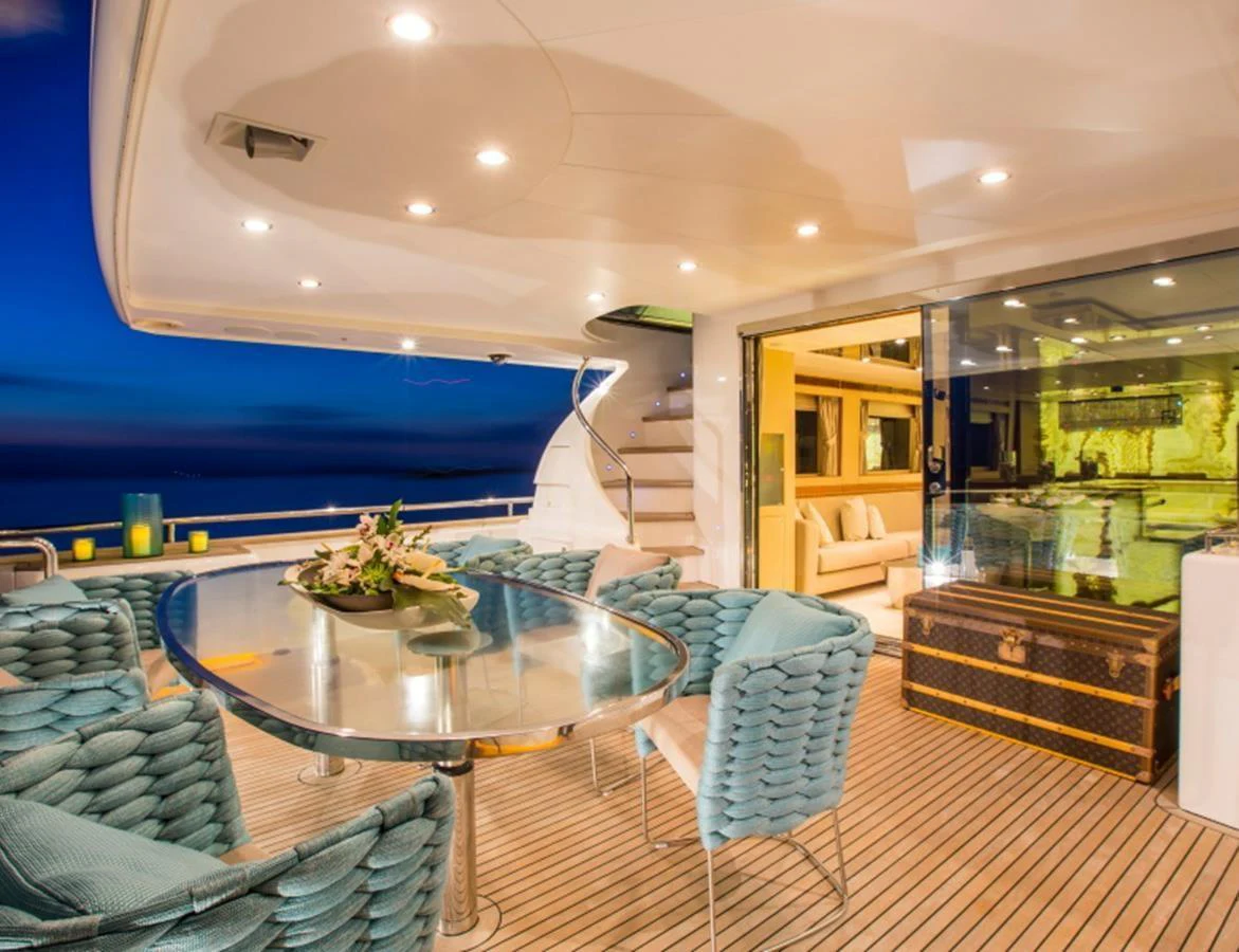 The aft deck features a stylish dining area with a glass table and plush seating, perfect for evening gatherings. aboard MR & MRS SMITH Yacht for Sale