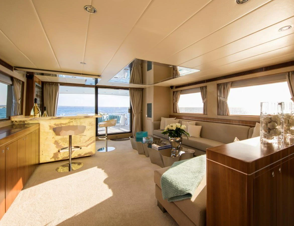 The salon features elegant furnishings, large windows, and a stylish bar area with a view of the sea. aboard MR & MRS SMITH Yacht for Sale
