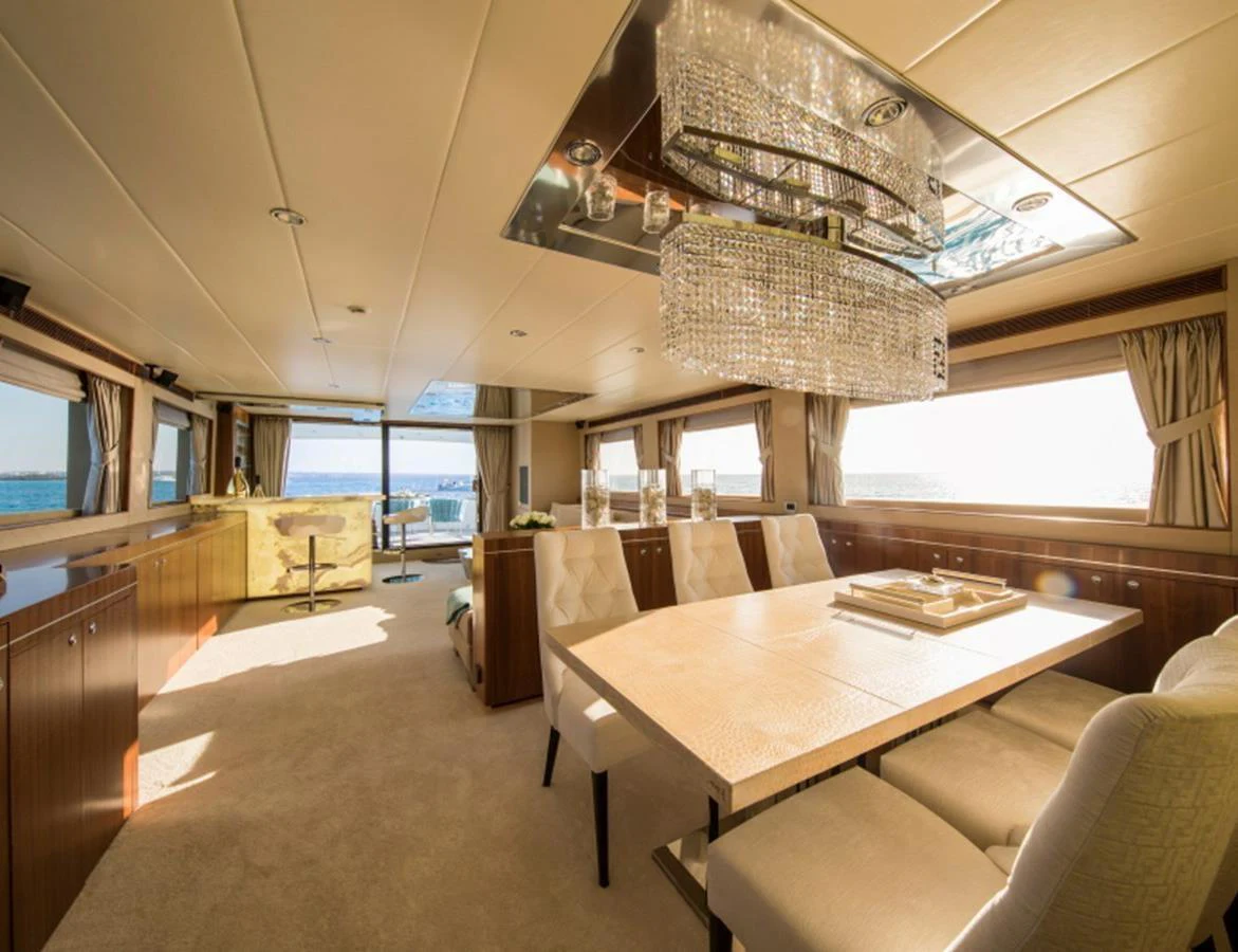 The yacht's dining area features elegant furnishings and a stunning chandelier, offering a luxurious setting for meals. aboard MR & MRS SMITH Yacht for Sale