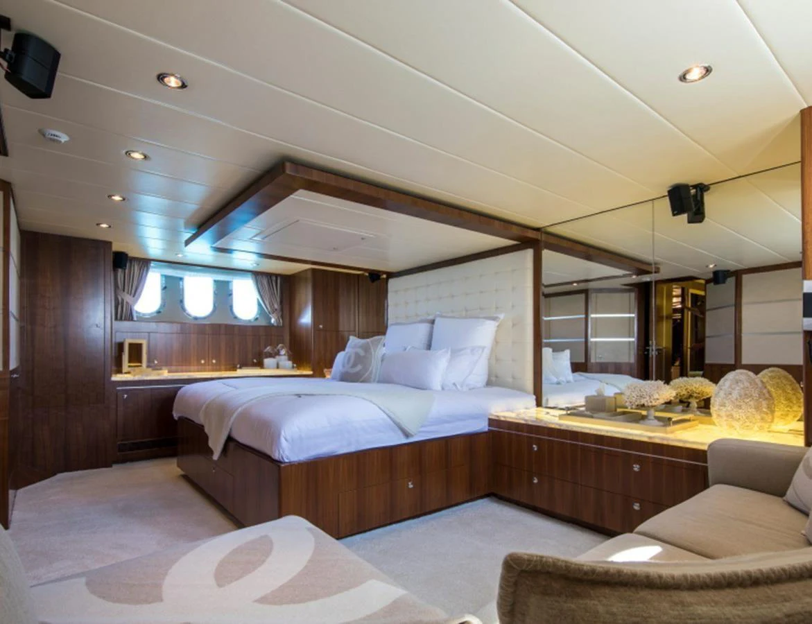 The master stateroom features a luxurious bed with elegant wood paneling and ample natural light. aboard MR & MRS SMITH Yacht for Sale