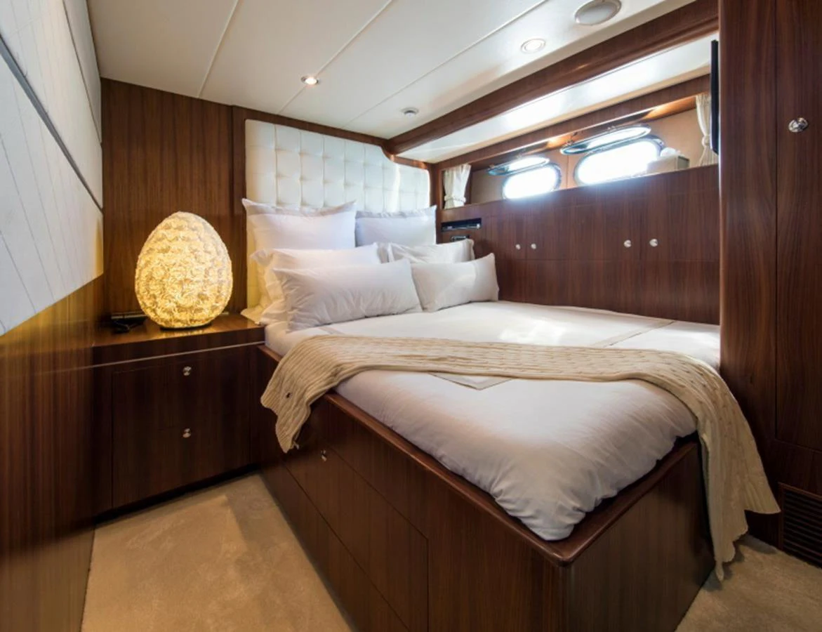 The stateroom features a cozy double bed with elegant wooden finishes and soft ambient lighting. aboard MR & MRS SMITH Yacht for Sale