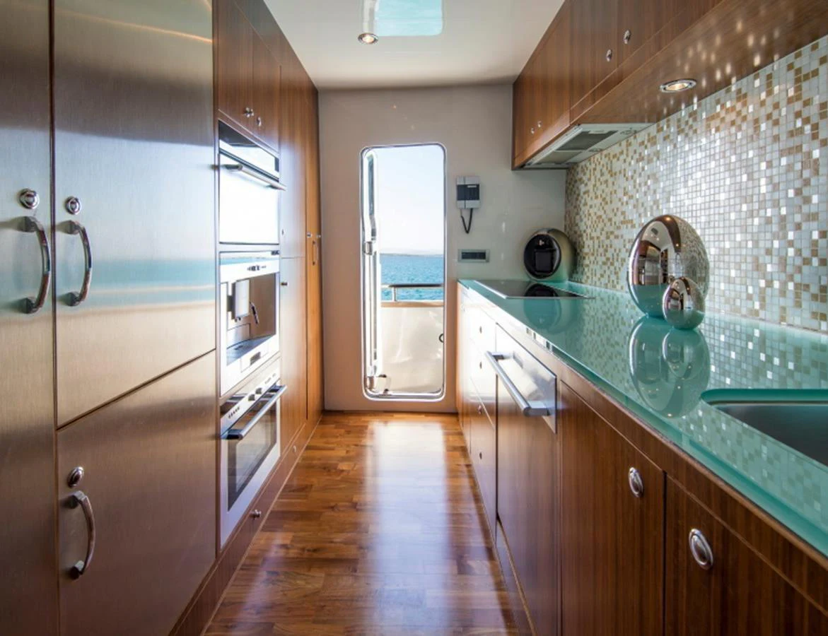 A sleek and modern galley with stainless steel appliances and a view of the sea through the door. aboard MR & MRS SMITH Yacht for Sale
