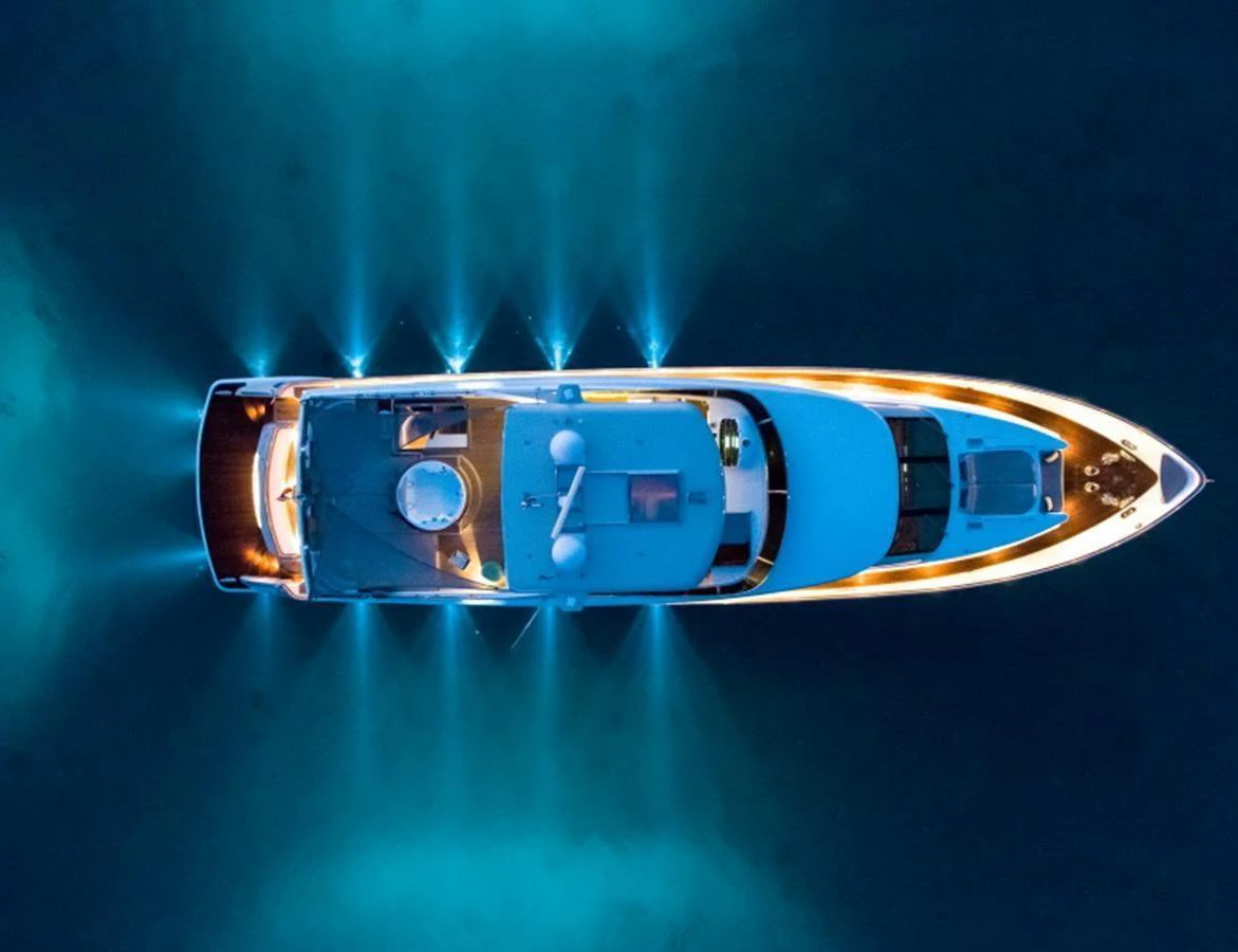 An aerial view of a yacht illuminated by underwater lights in a serene setting. aboard MR & MRS SMITH Yacht for Sale