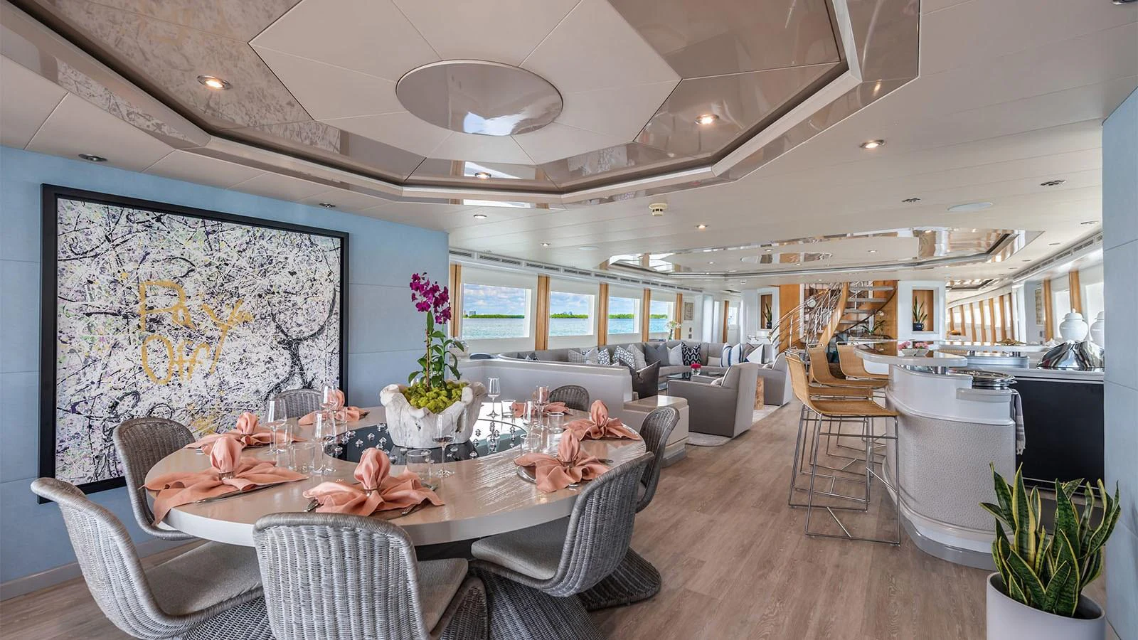 a large dining room with a large painting on the wall aboard SURINA Yacht for Sale