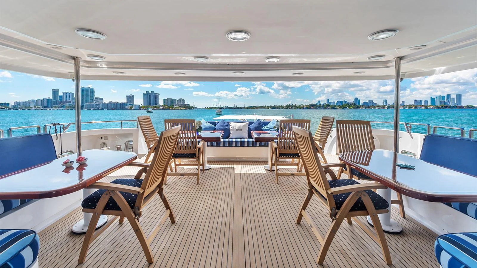a room with a table chairs and a view of a city aboard SURINA Yacht for Sale