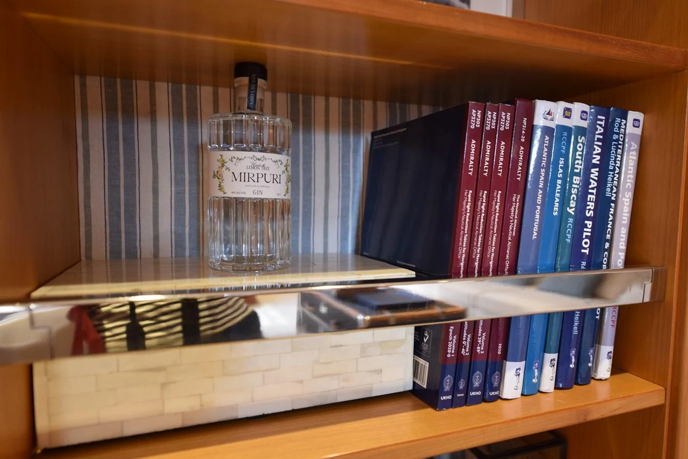 a bottle of water on a bookshelf aboard GREEN EYES Yacht for Sale