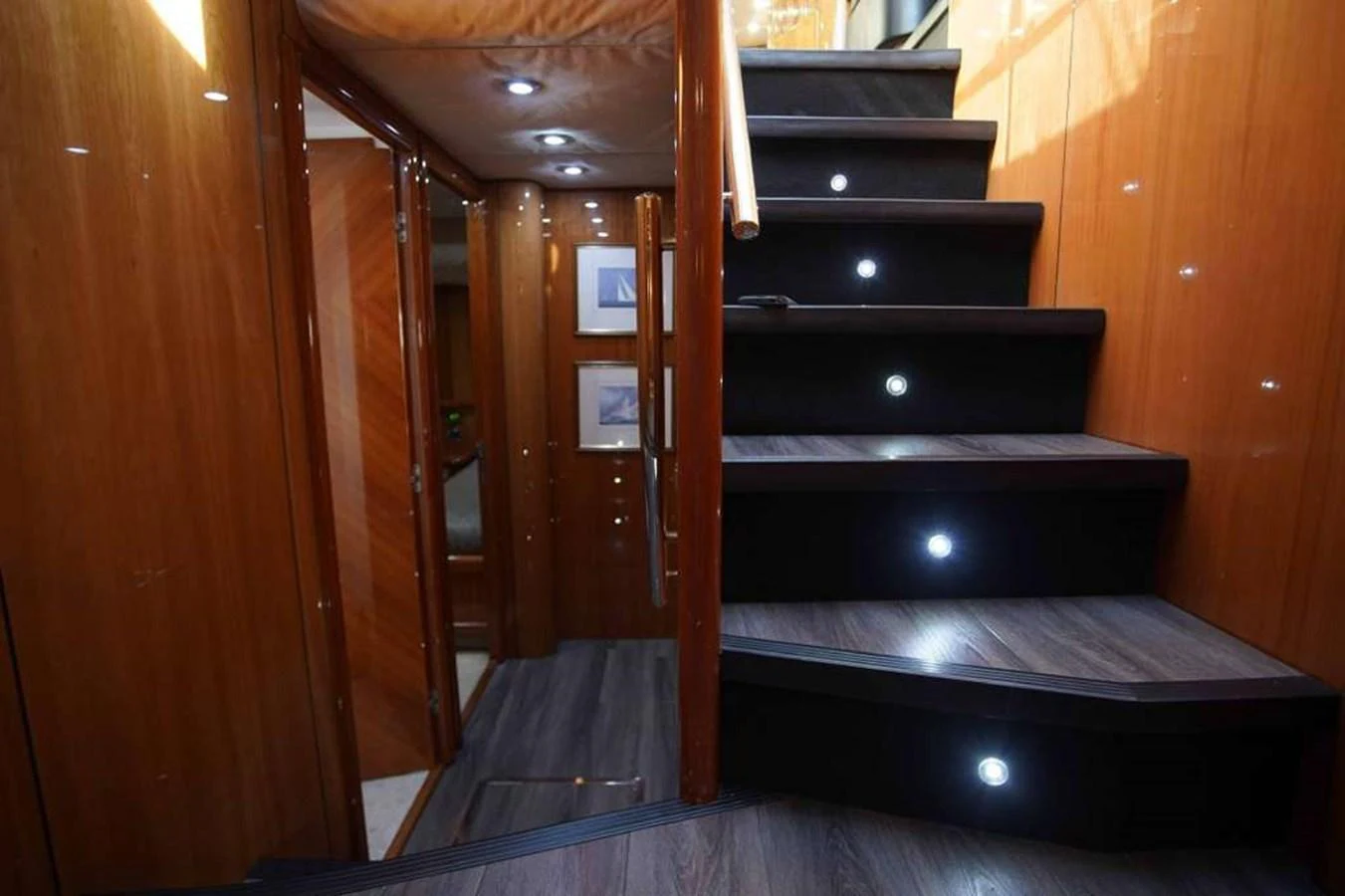 The yacht's interior features a sleek, modern staircase with illuminated steps and polished wood finishes. aboard 2006 SUNSEEKER MANHATTAN 'FINS UP' Yacht for Sale