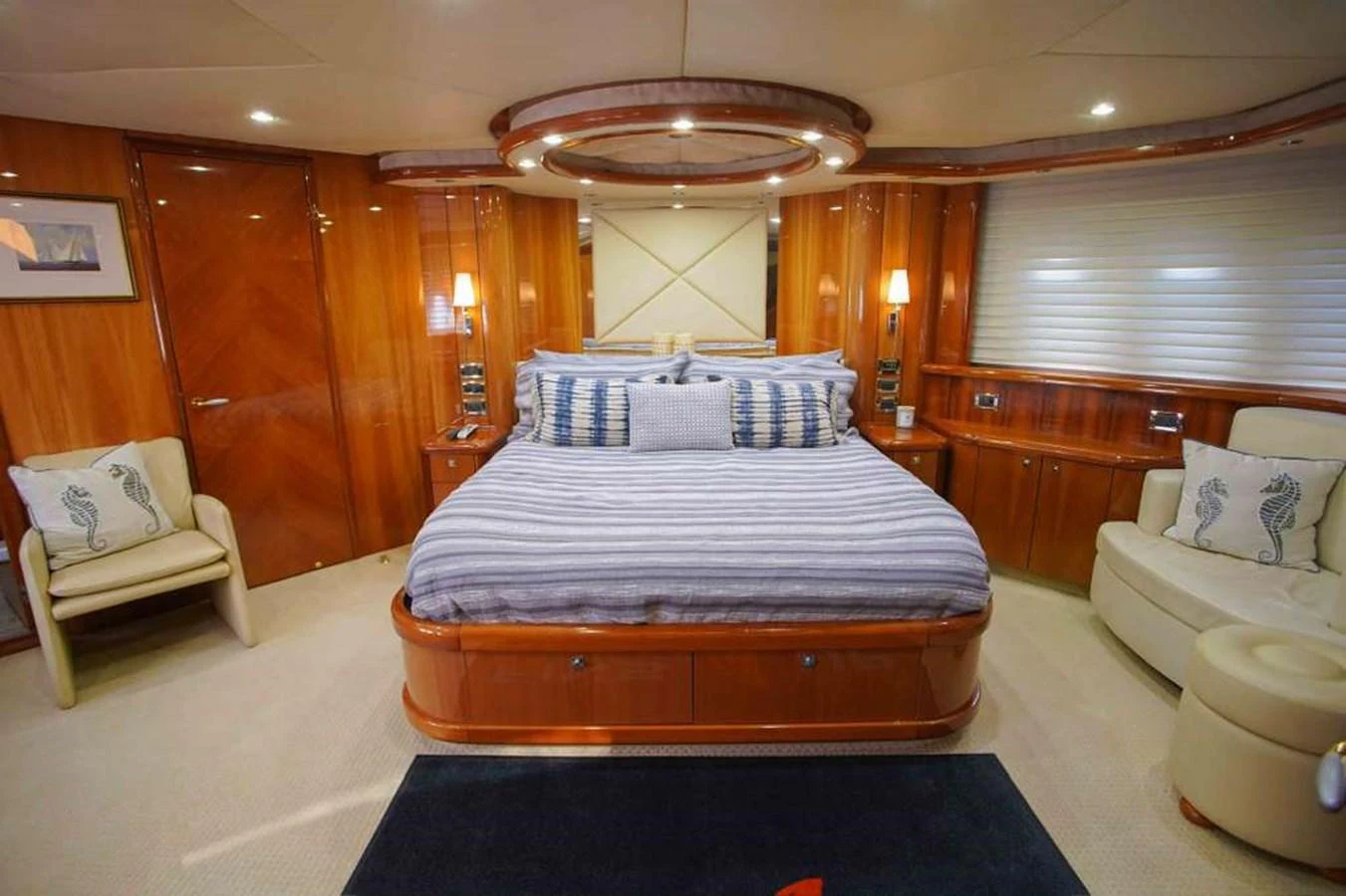 The master stateroom features a luxurious bed with elegant wood paneling and ambient lighting. aboard 2006 SUNSEEKER MANHATTAN 'FINS UP' Yacht for Sale