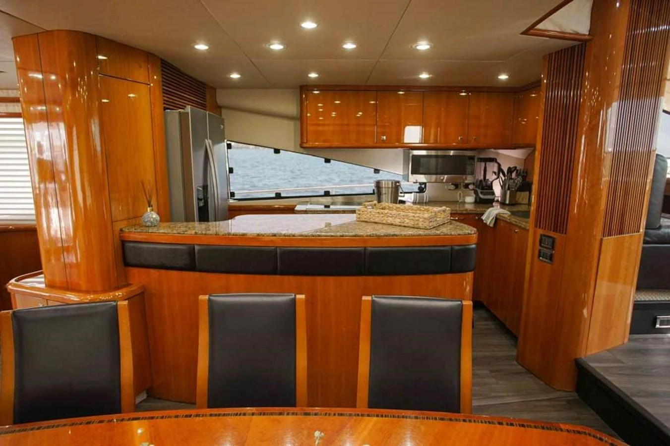 The yacht's galley features polished wood cabinetry, modern appliances, and a sleek dining area. aboard 2006 SUNSEEKER MANHATTAN 'FINS UP' Yacht for Sale