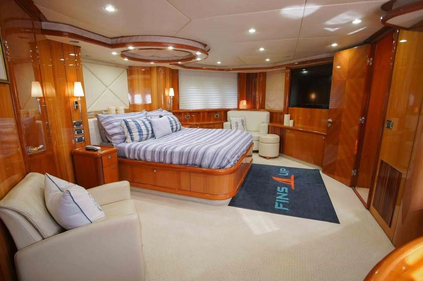 The master stateroom features a spacious bed, comfortable seating, and elegant wooden finishes. aboard 2006 SUNSEEKER MANHATTAN 'FINS UP' Yacht for Sale