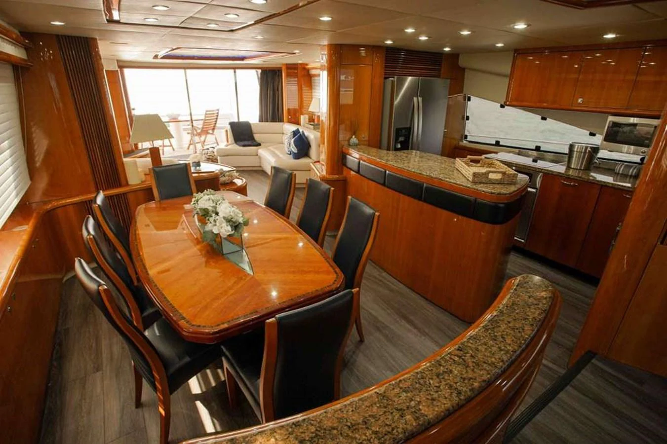 The yacht's interior features a luxurious dining area adjacent to a well-equipped galley, with elegant wood finishes and modern amenities. aboard 2006 SUNSEEKER MANHATTAN 'FINS UP' Yacht for Sale