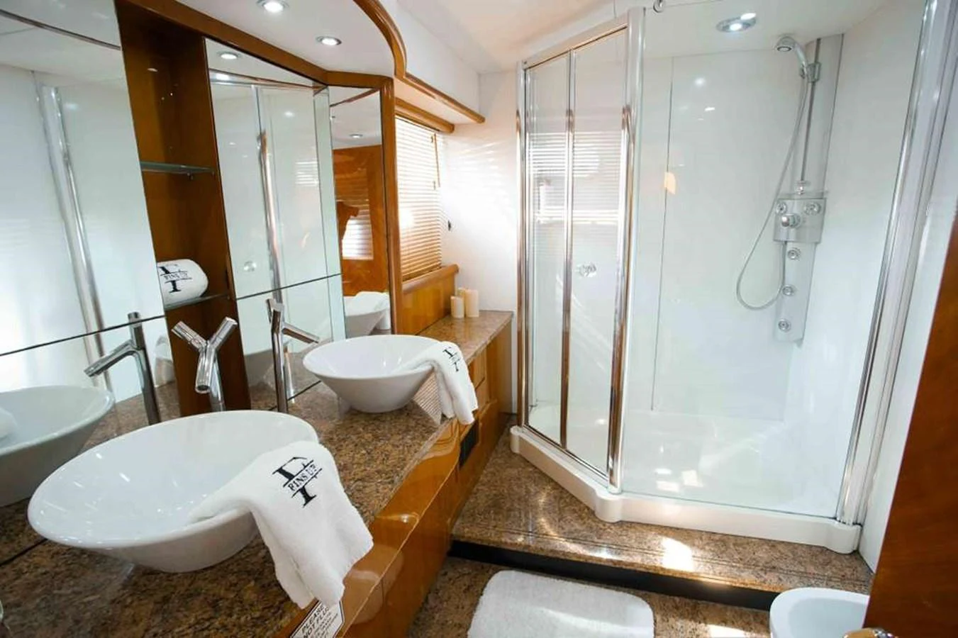 The yacht's bathroom features a spacious shower, elegant sinks, and luxurious finishes. aboard 2006 SUNSEEKER MANHATTAN 'FINS UP' Yacht for Sale