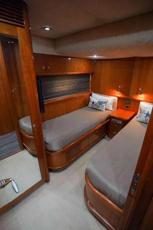 A cozy guest cabin with twin beds and warm wooden finishes. aboard 2006 SUNSEEKER MANHATTAN 'FINS UP' Yacht for Sale
