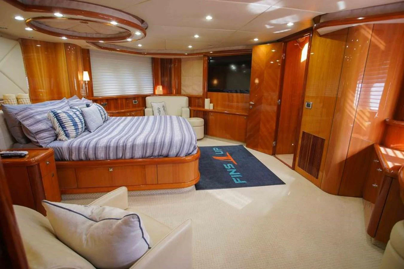 The master stateroom features a spacious bed, elegant wood finishes, and ample natural light. aboard 2006 SUNSEEKER MANHATTAN 'FINS UP' Yacht for Sale
