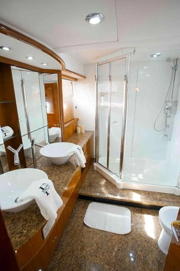 The yacht's bathroom features a spacious shower, elegant countertops, and modern fixtures. aboard 2006 SUNSEEKER MANHATTAN 'FINS UP' Yacht for Sale