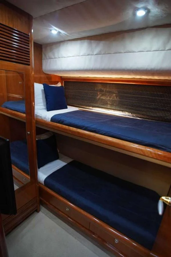 The guest cabin features cozy bunk beds with plush bedding and warm wood finishes. aboard 2006 SUNSEEKER MANHATTAN 'FINS UP' Yacht for Sale