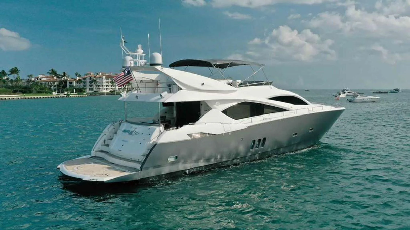 A sleek and modern yacht cruising on calm waters with a scenic coastal backdrop. aboard 2006 SUNSEEKER MANHATTAN 'FINS UP' Yacht for Sale