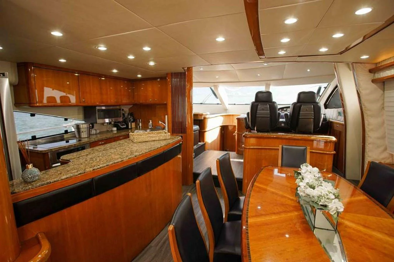 The yacht's interior features a luxurious galley and dining area with elegant wood finishes and modern amenities. aboard 2006 SUNSEEKER MANHATTAN 'FINS UP' Yacht for Sale