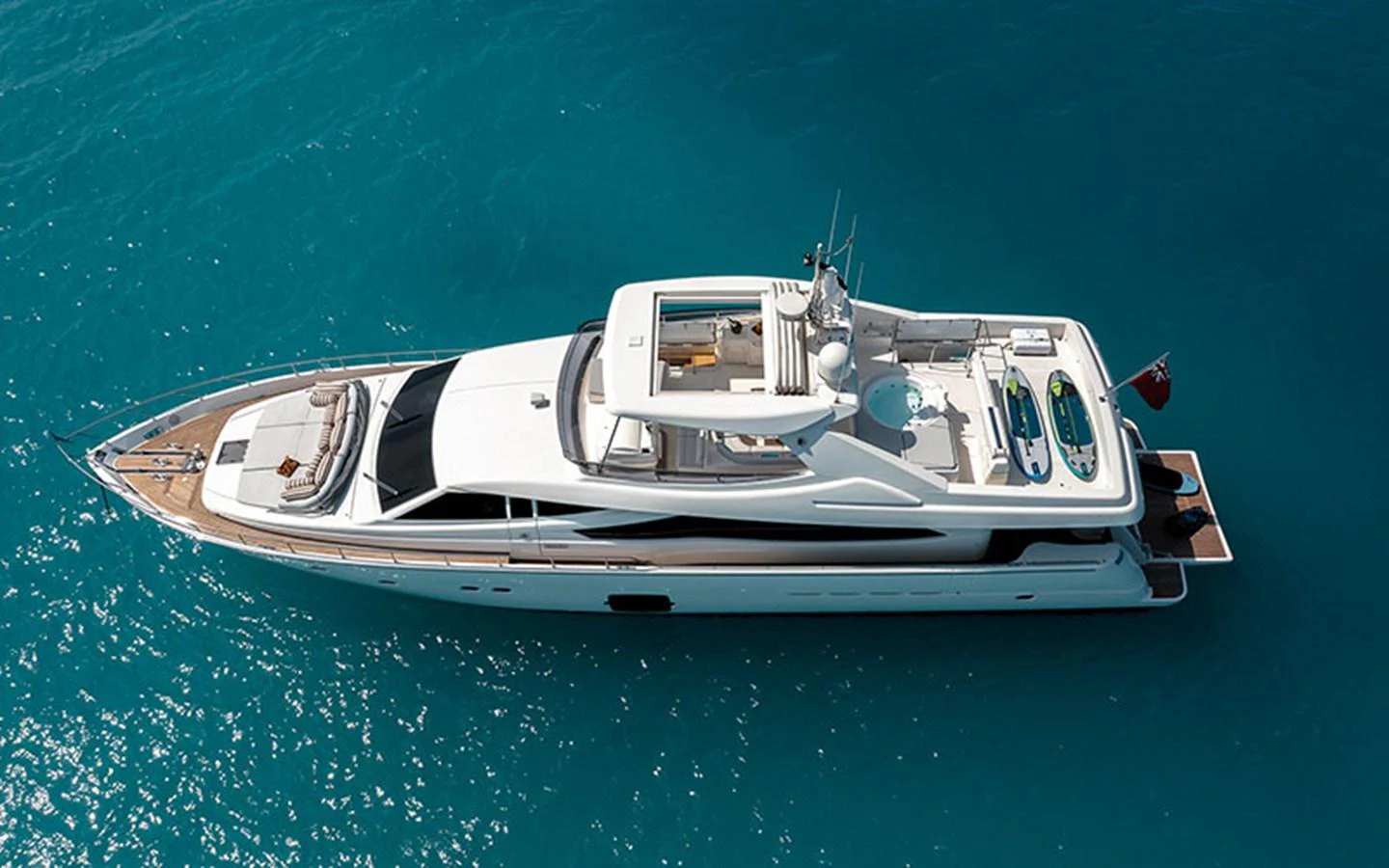 A sleek and modern yacht cruises on clear blue waters, showcasing its elegant design and spacious deck areas. aboard ONYX Yacht for Sale