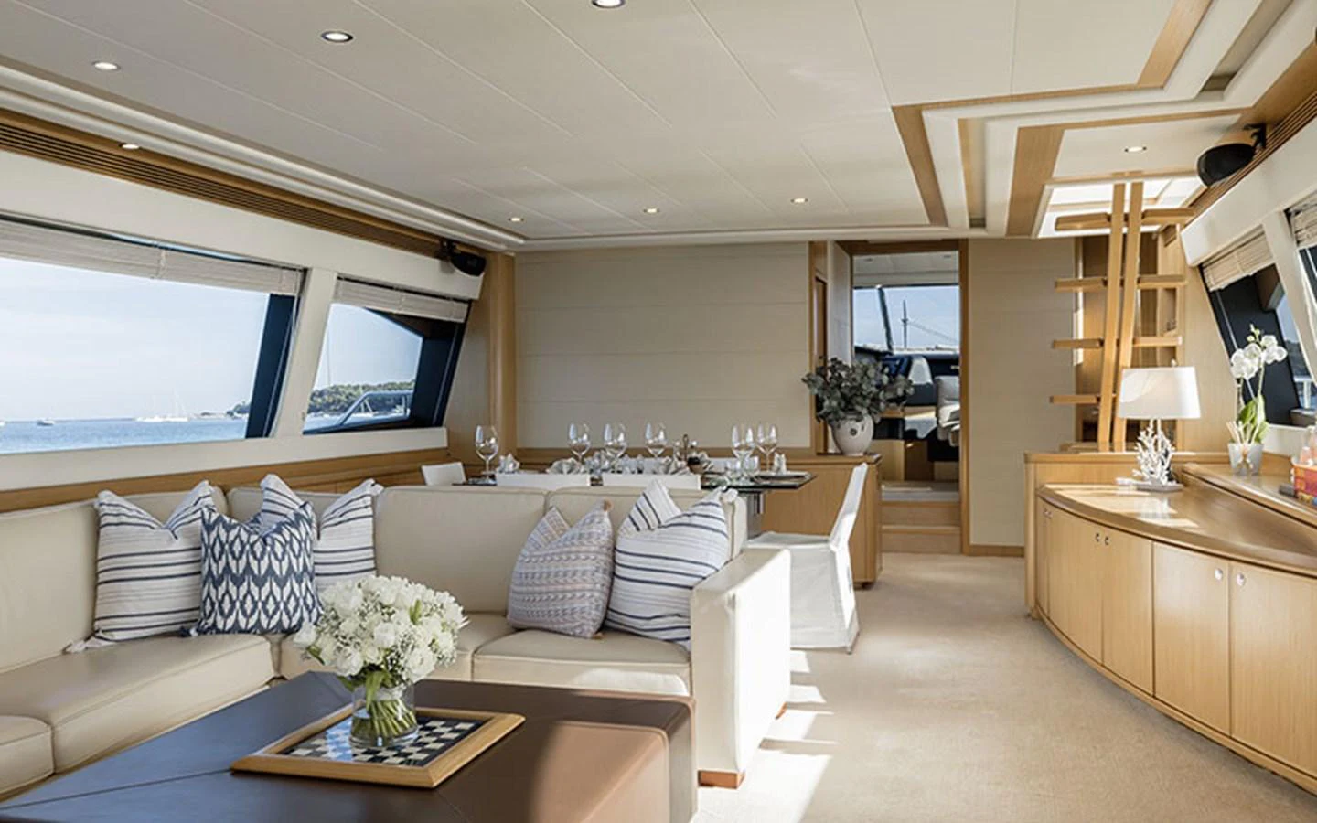 The yacht's salon features elegant seating, a dining area, and large windows offering stunning views. aboard ONYX Yacht for Sale