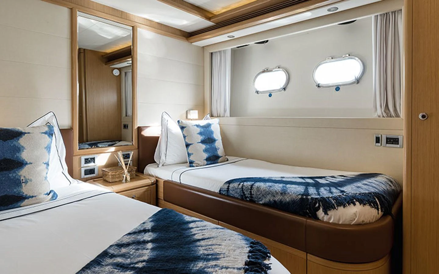 The twin stateroom offers a cozy and stylish retreat with natural light streaming through the portholes. aboard ONYX Yacht for Sale