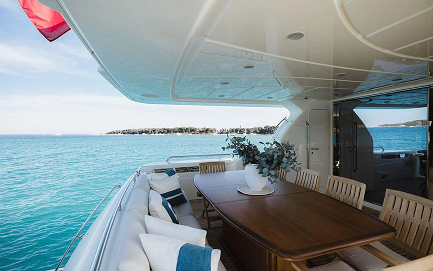 The aft deck features a spacious dining area with a large table and comfortable seating, perfect for enjoying meals with a view of the sea. aboard ONYX Yacht for Sale