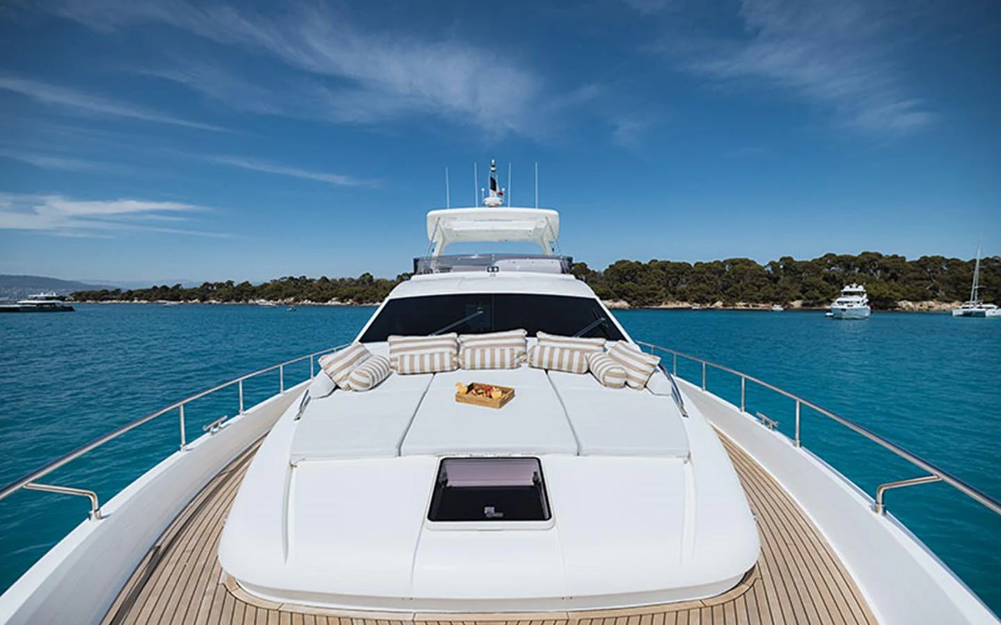 The yacht's foredeck features a spacious sunbathing area with plush cushions, set against a stunning seascape. aboard ONYX Yacht for Sale