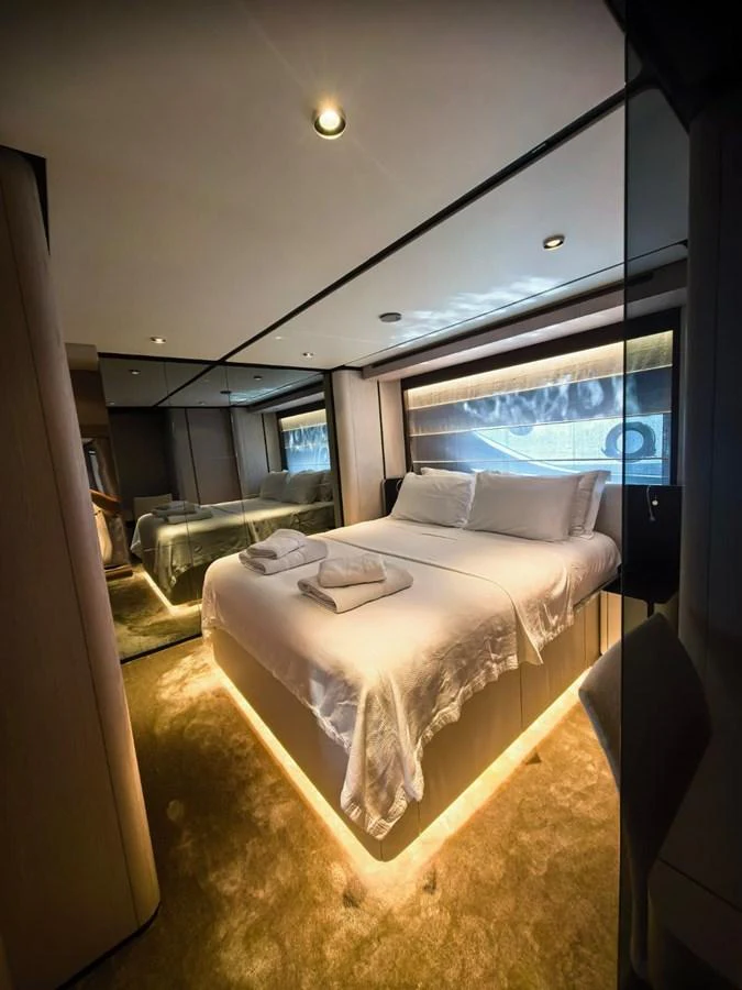 A luxurious stateroom featuring a plush bed with ambient lighting and modern decor. aboard TBN 860 Yacht for Sale