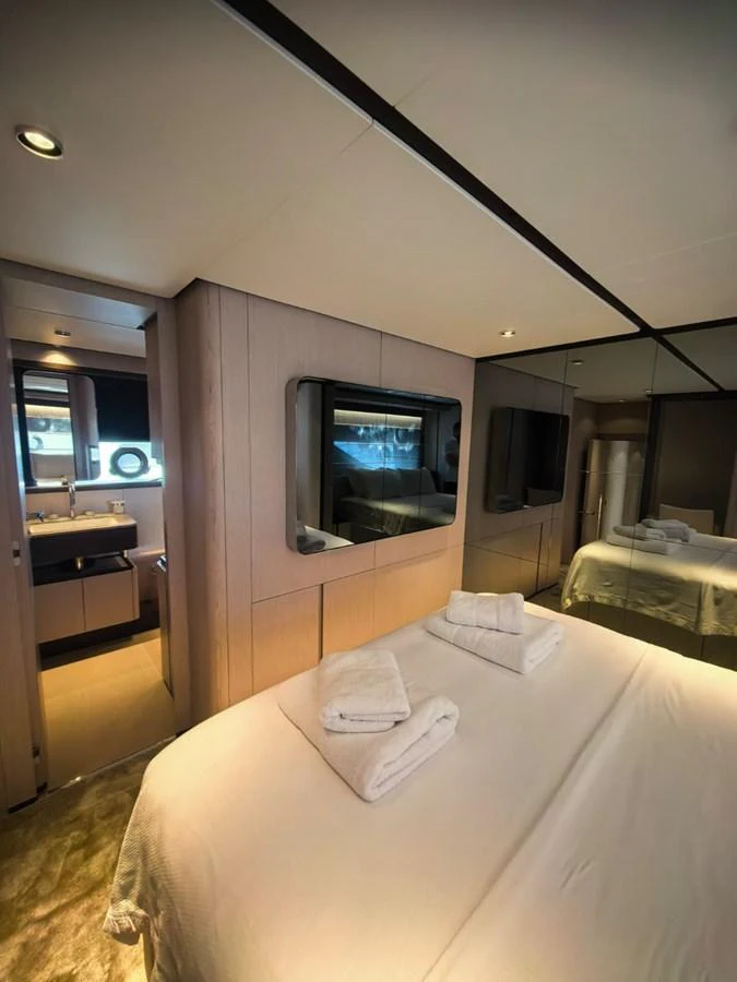 The stateroom features a comfortable bed with neatly arranged towels and a modern ensuite bathroom. aboard TBN 860 Yacht for Sale