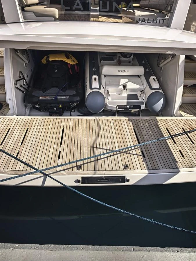 The image shows the tender garage of a yacht, featuring a stored tender and a jet ski. aboard TBN 860 Yacht for Sale