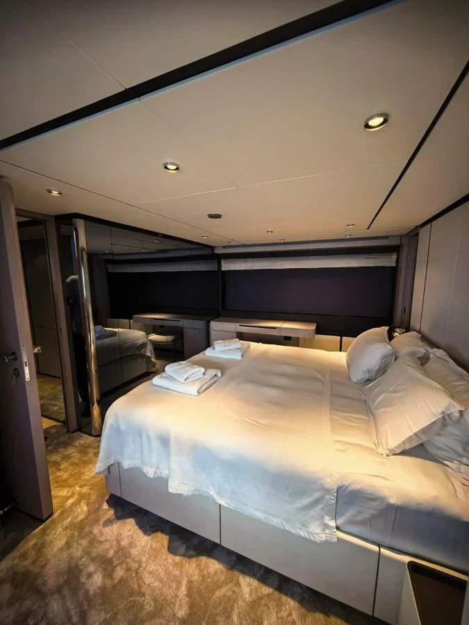 The stateroom features a luxurious bed with plush linens and modern lighting. aboard TBN 860 Yacht for Sale