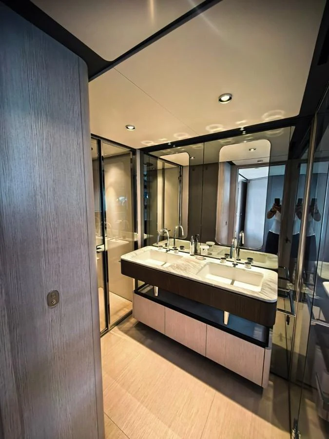 The yacht's bathroom features a modern double sink vanity with sleek fixtures and ample lighting. aboard TBN 860 Yacht for Sale