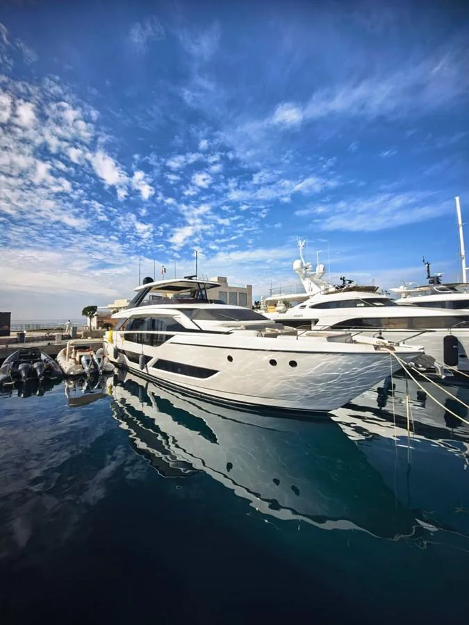 A sleek and modern yacht is docked at a marina under a clear blue sky. aboard TBN 860 Yacht for Sale