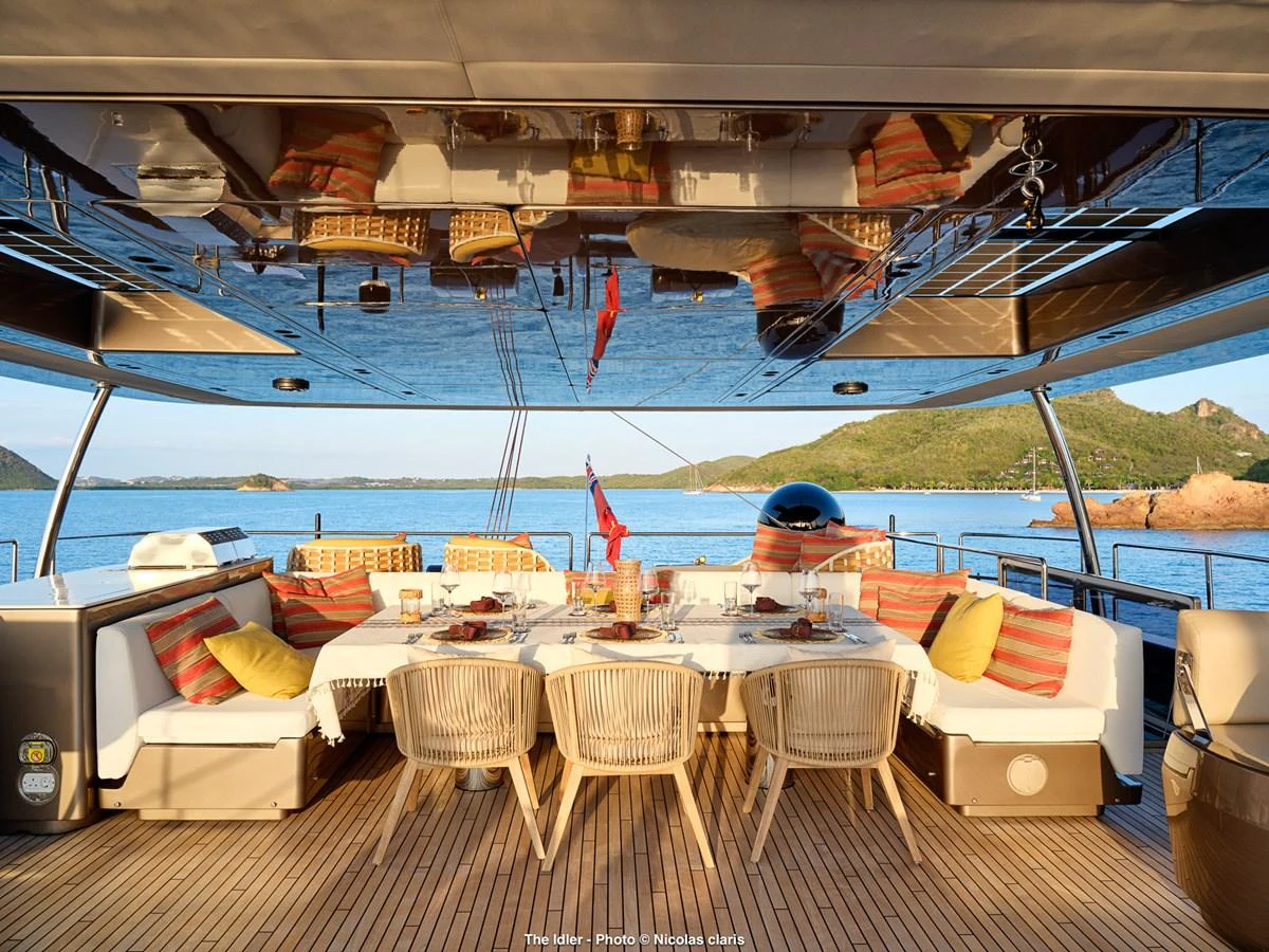 The aft deck offers a luxurious dining area with stunning views of the surrounding waters. aboard THE IDLER Yacht for Sale