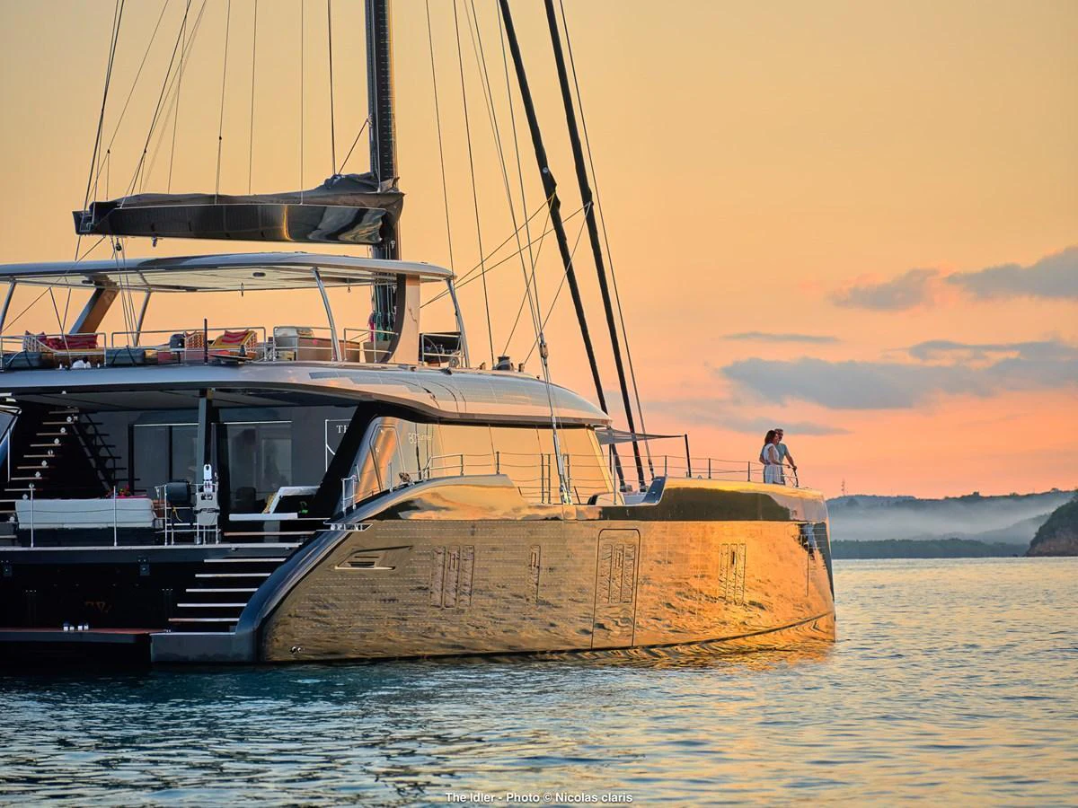 A luxurious yacht basks in the golden glow of sunset, showcasing its sleek design and elegant lines. aboard THE IDLER Yacht for Sale
