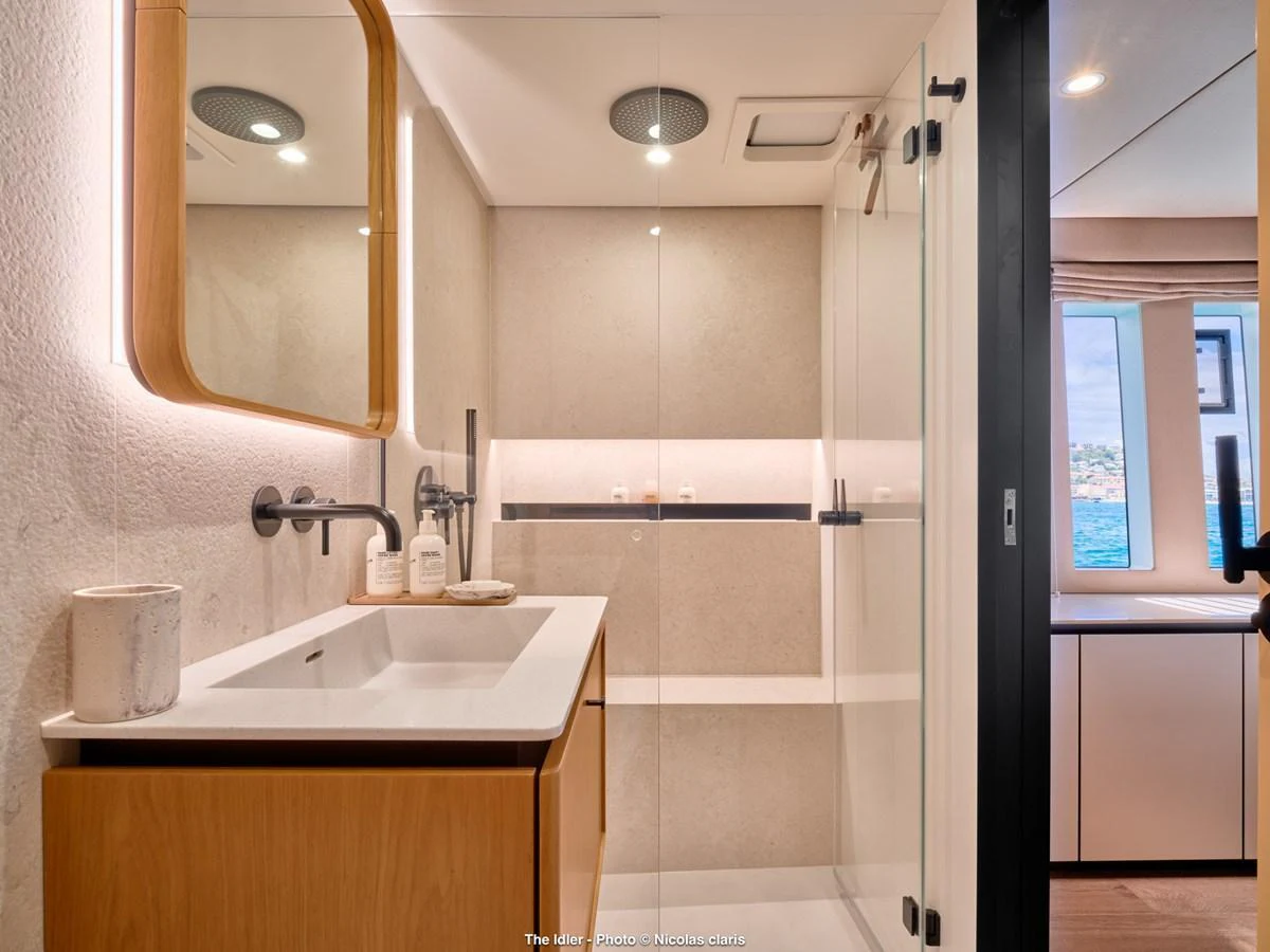 A modern and elegant bathroom with a spacious shower and stylish fixtures. aboard THE IDLER Yacht for Sale
